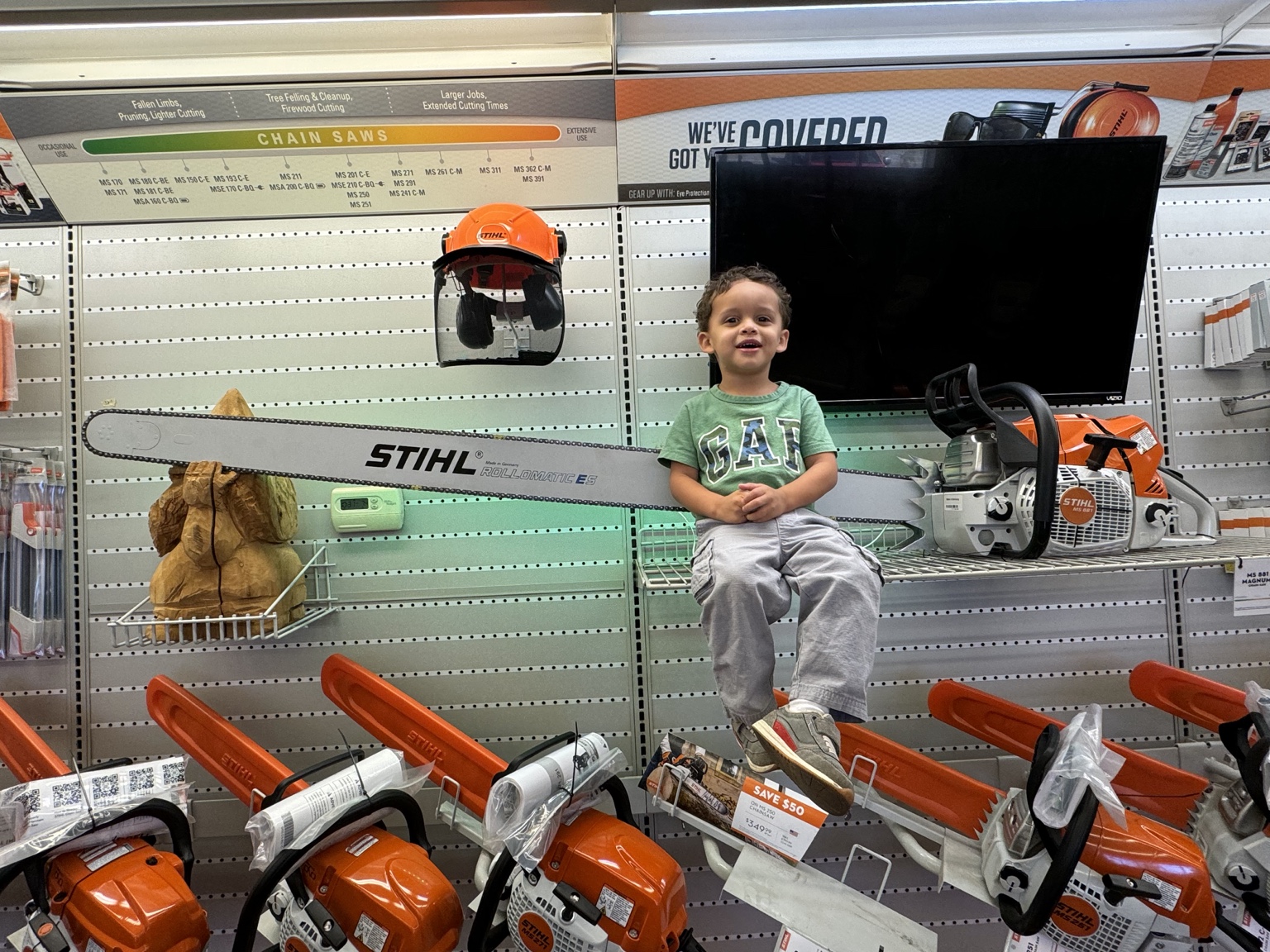 Steve's son sitting on a shelf in the saw aisle at the dealer